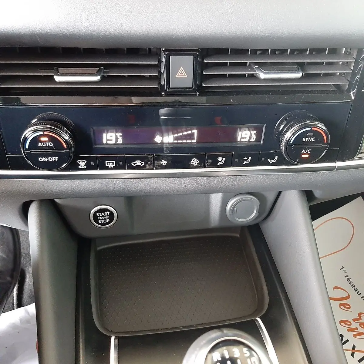 Tableau de bord du Nissan Qashqai blanc lunaire 2022, vue rapprochée sur commandes climatisation et bouton start/stop.