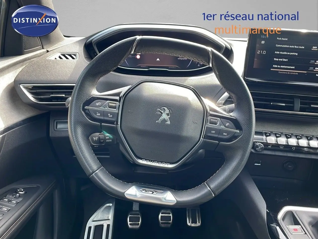Vue intérieure centrée sur le volant GT de la Peugeot 3008 2023, avec tableau de bord et console moderne visibles.