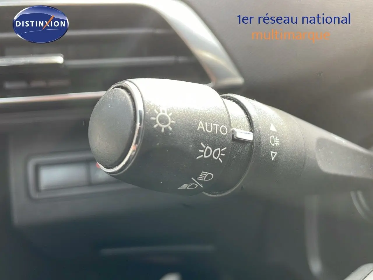 Gros plan sur la commande des phares du Peugeot 3008 gris platinium, intérieur moderne et épuré.