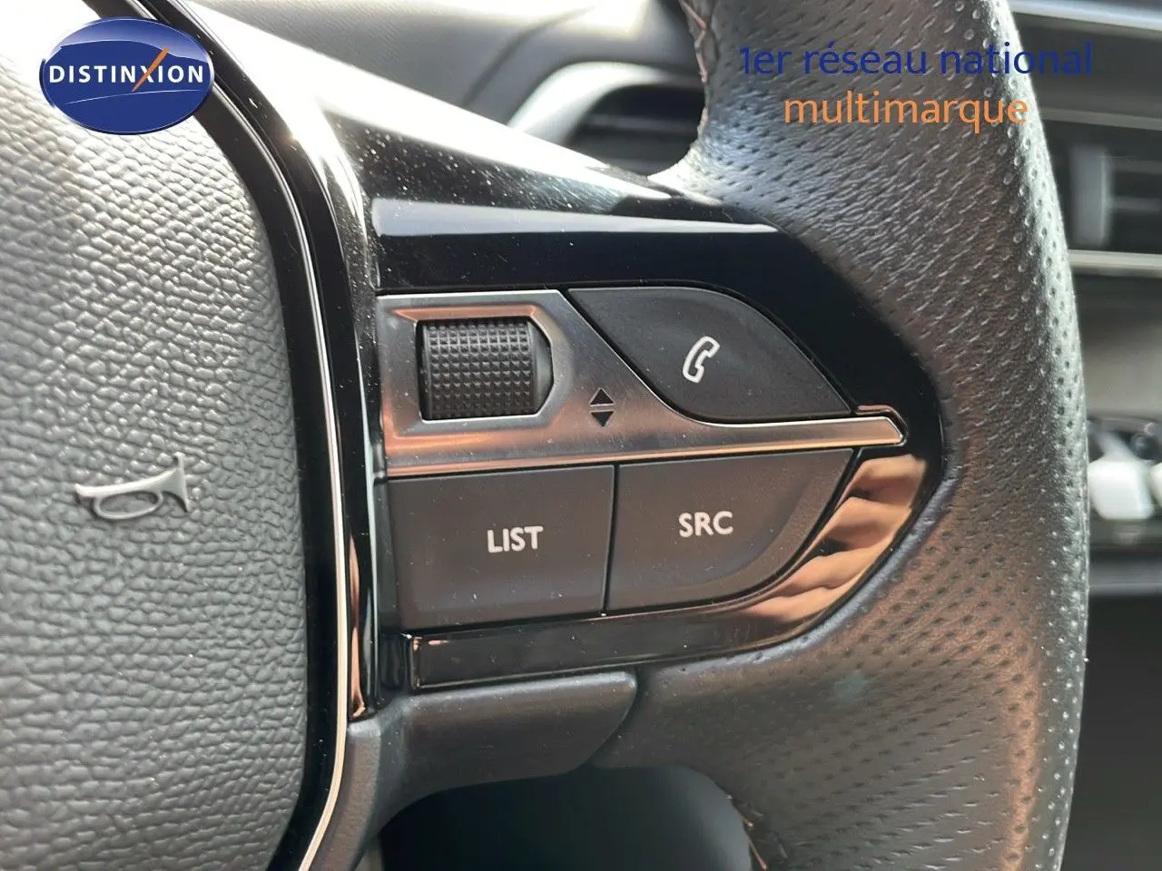 Gros plan sur les commandes gauche du volant en cuir noir du Peugeot 3008 gris platinium 2023.