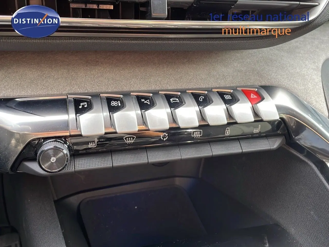 Gros plan sur la rangée de commandes métalliques et boutons noirs du tableau de bord du Peugeot 3008 gris platinium de 2023.