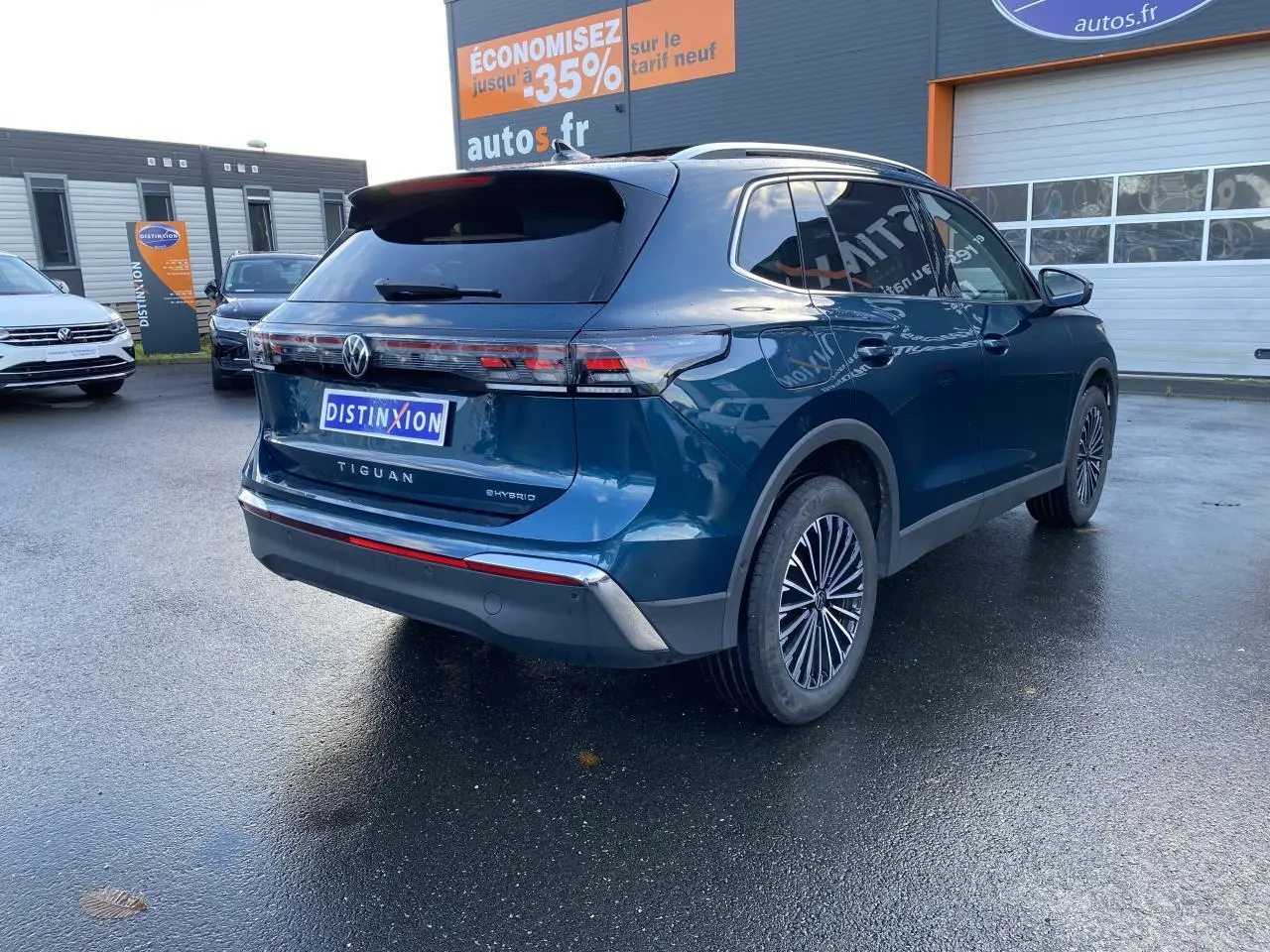 Vue 3/4 arrière droite du Volkswagen Tiguan hybride rechargeable bleu Nightshade avec feux LED et jantes stylisées.