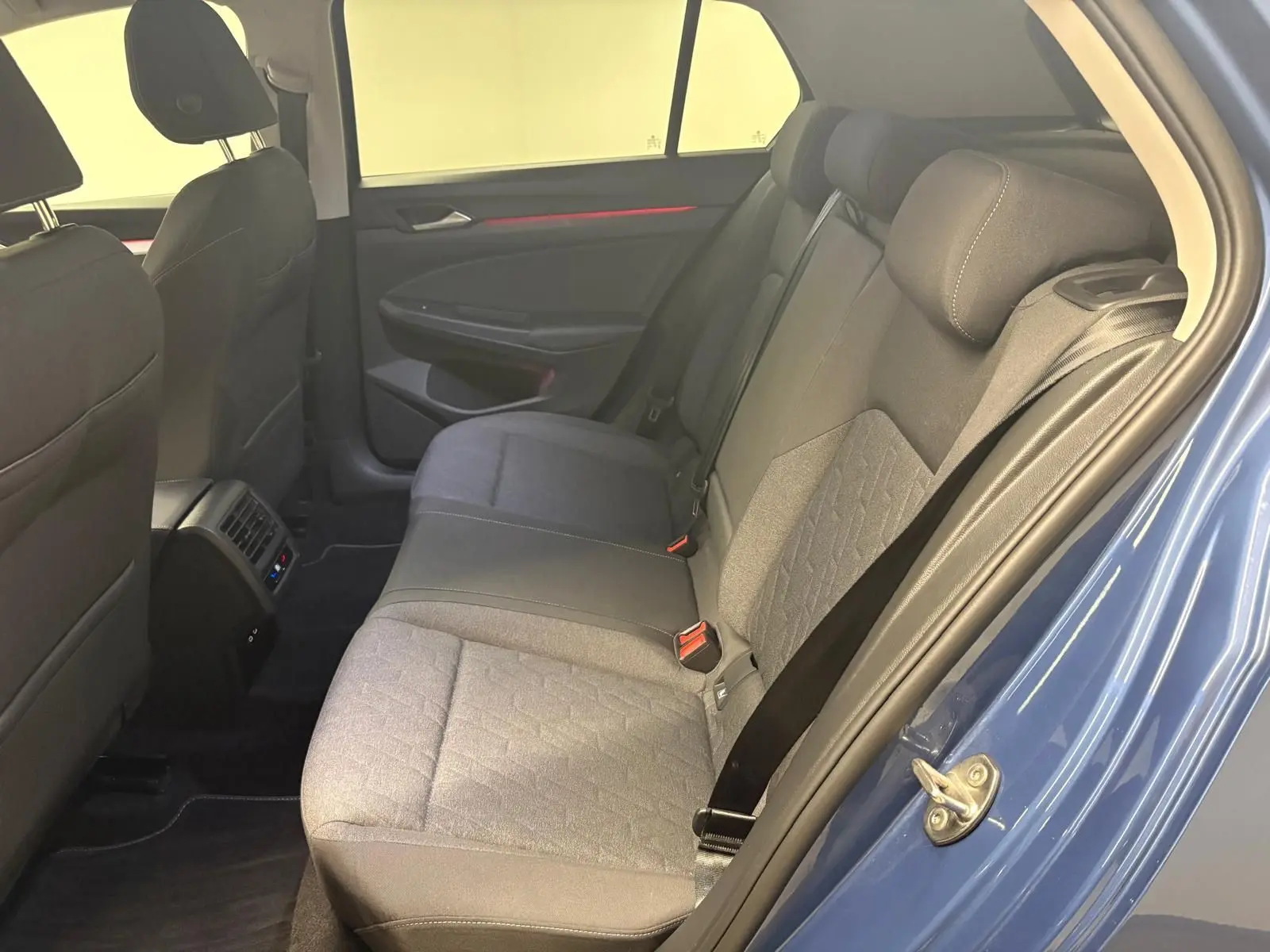 Vue intérieure arrière côté droit de la Volkswagen Golf 1.5 eTSI 116 DSG7 Bleu Anémone, montrant les sièges tissu et les ceintures.