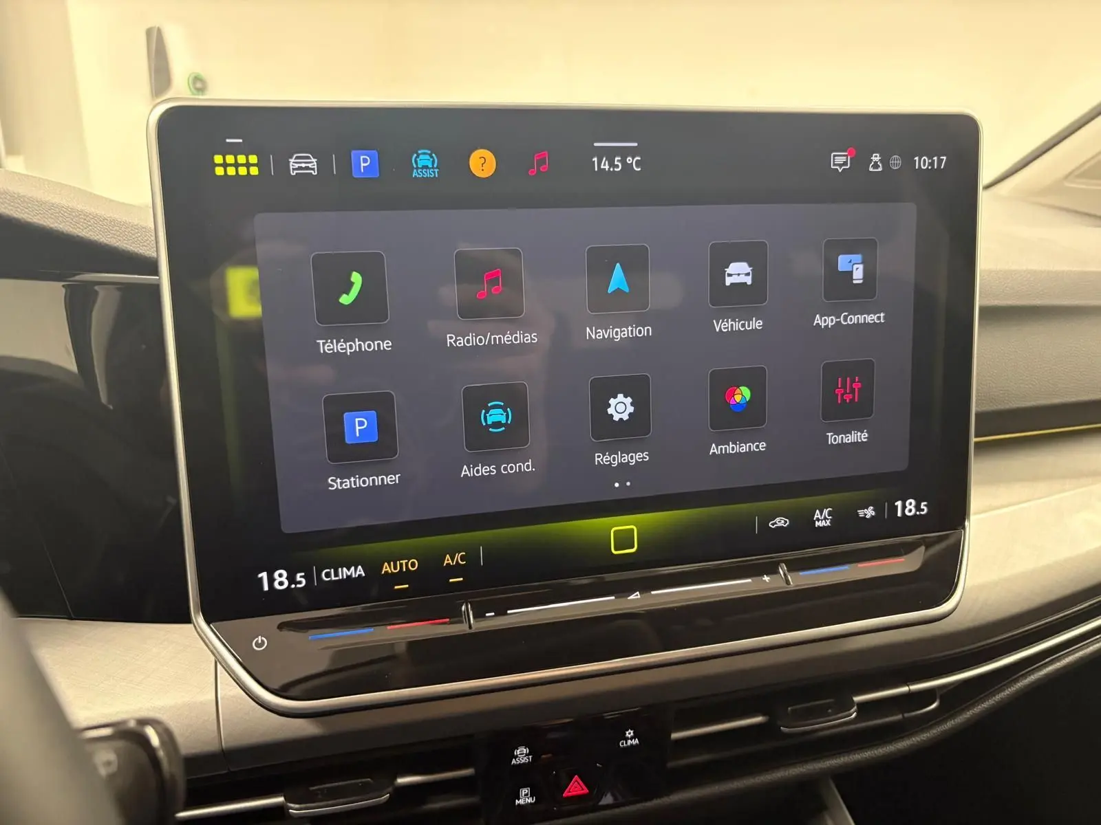 Écran tactile central affichant les options multimédia et climatisation dans l’habitacle d’une Volkswagen Golf 2025.