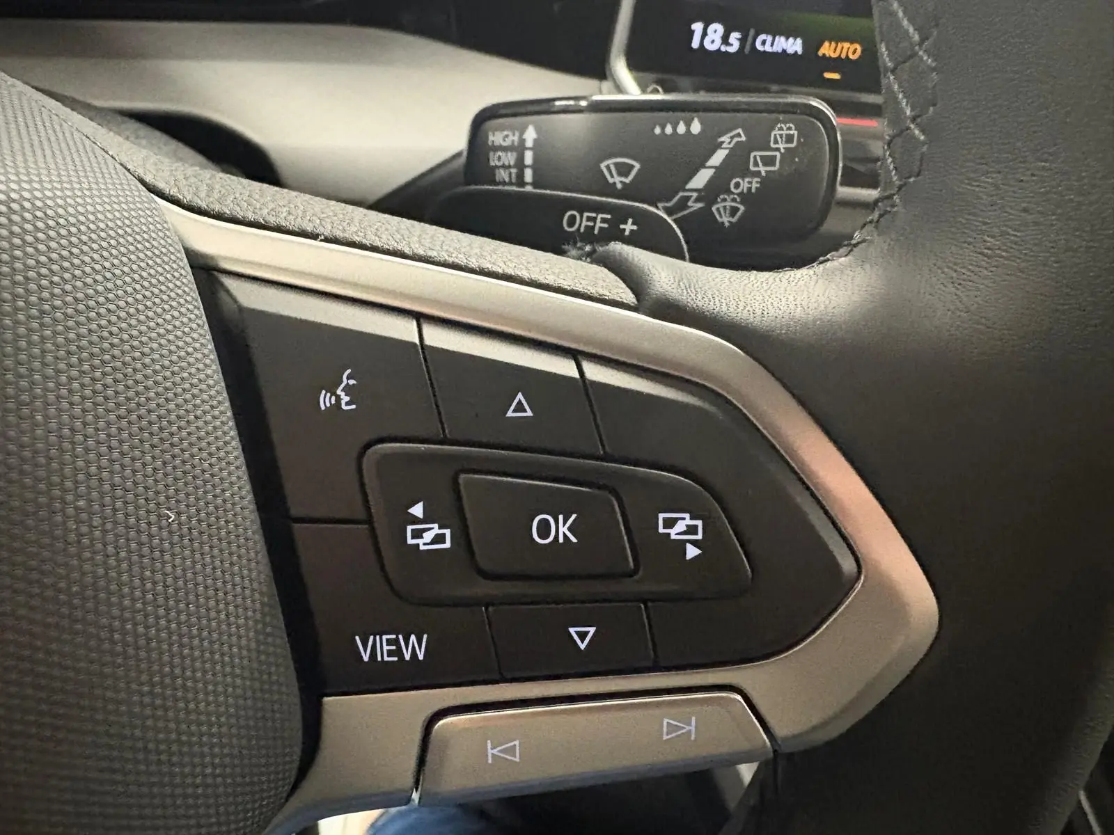 Gros plan sur les commandes au volant côté gauche de la Volkswagen Golf 1.5 eTSI 2025 en Bleu Anémone.