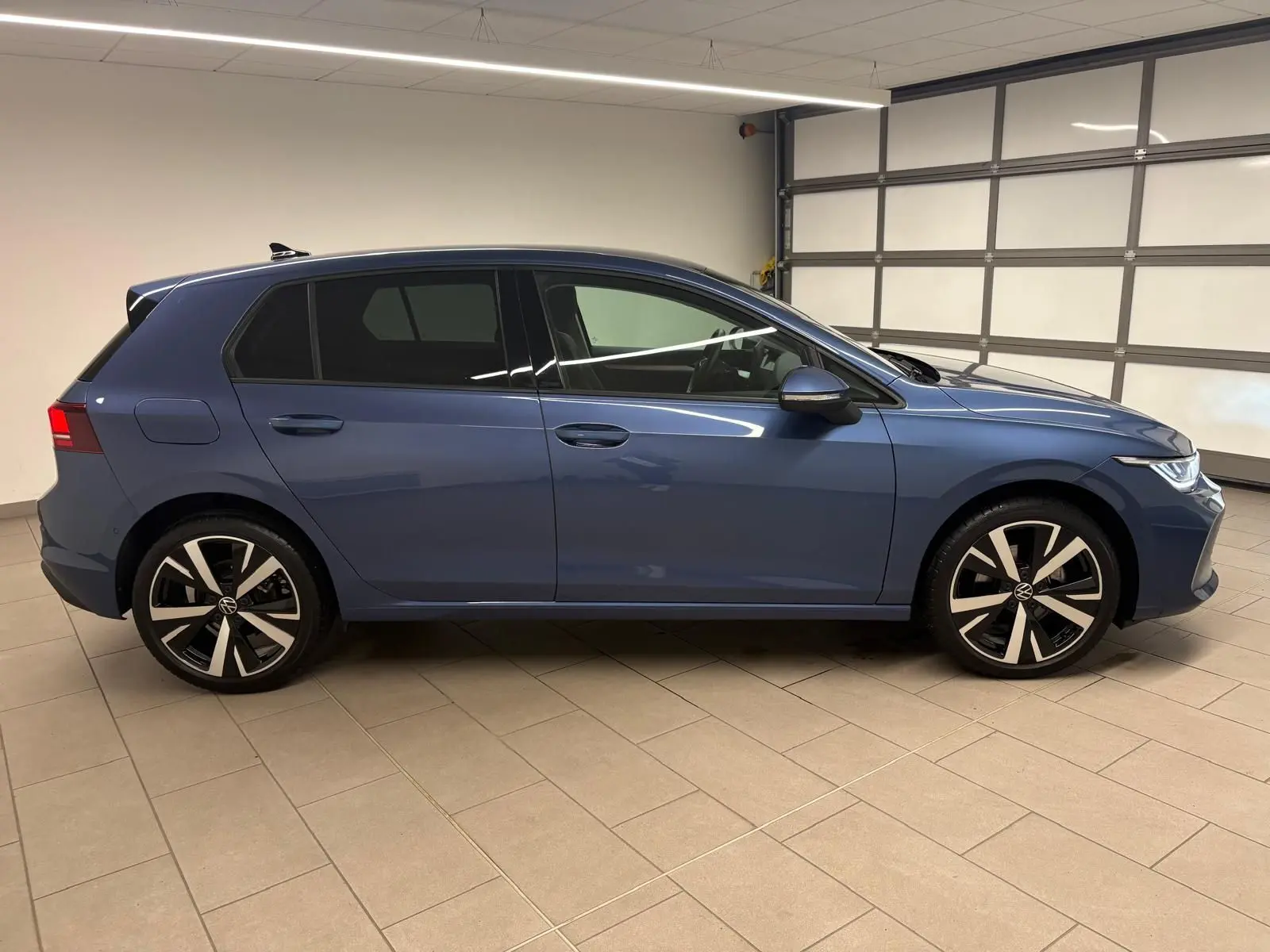 Vue de profil côté gauche d'une Volkswagen Golf 1.5 eTSI 116 DSG7 Bleu Anémone avec jantes alliage 18'' Catania.