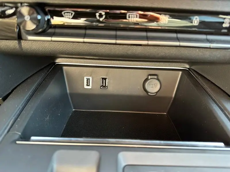 Gros plan intérieur sur la console centrale du Citroën C5 Aircross 2025, montrant ports USB et prise 12V.