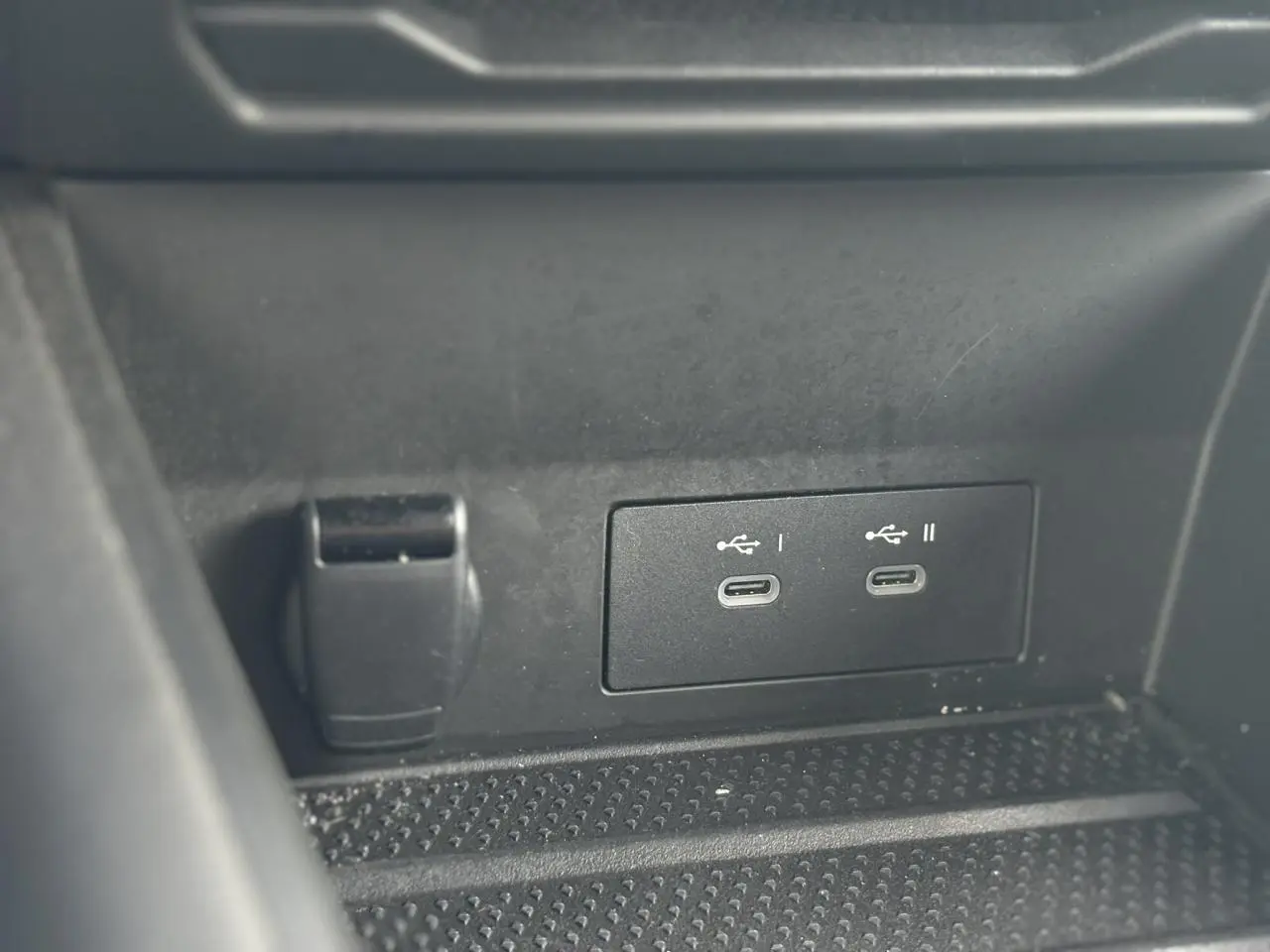 Détail des ports USB-C doubles et prise 12V dans le rangement central du Renault Symbioz E-Tech Full Hybrid bleu.