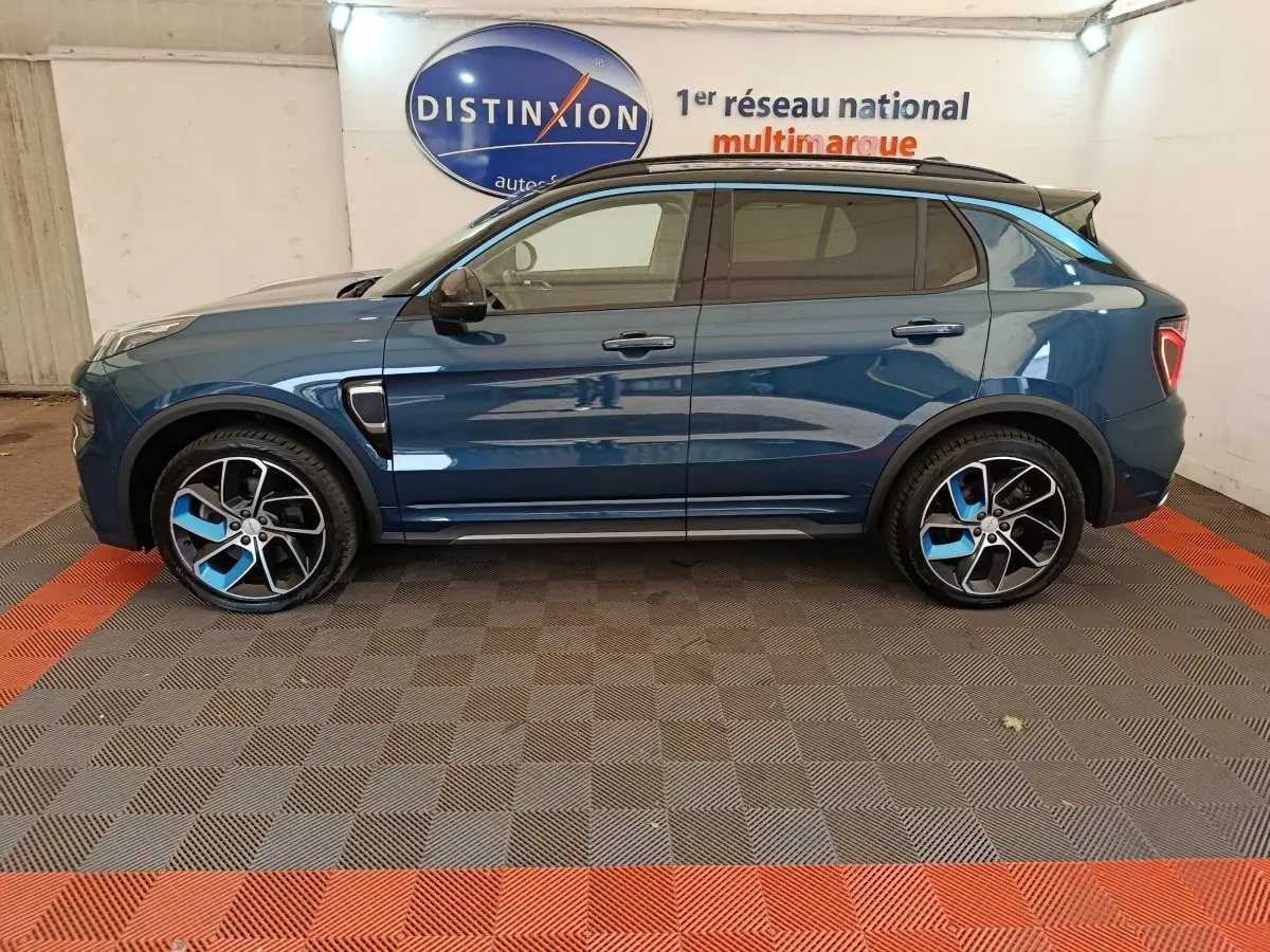 Vue de profil côté gauche du SUV LINK & CO 01 hybride rechargeable bleu avec jantes bicolores et toit noir.