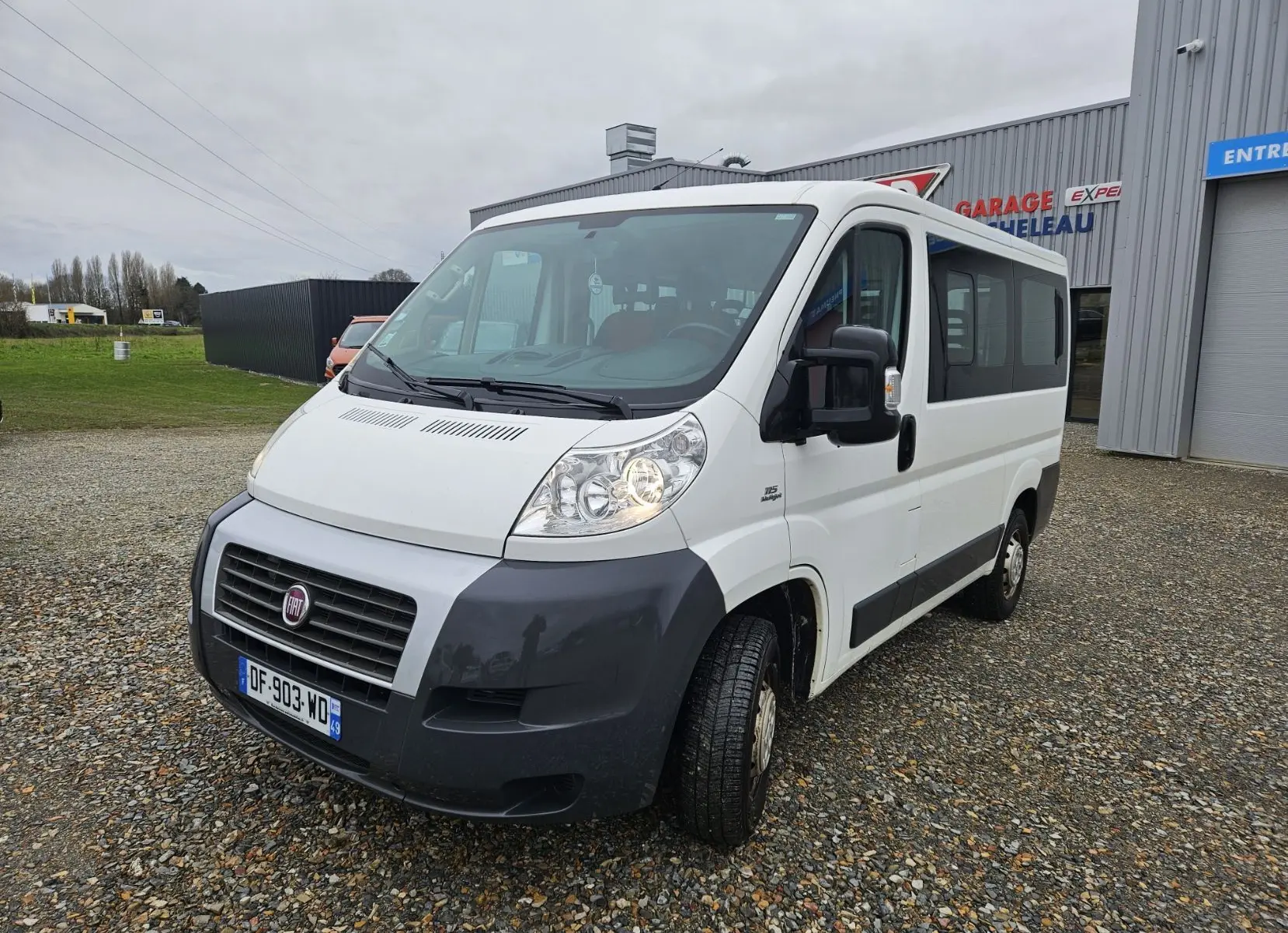 Fiat Ducato Combi blanc vu en 3/4 avant droit, fourgon 9 places avec pare-chocs noir et calandre distinctive.