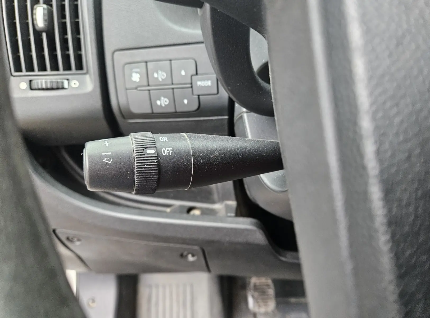 Gros plan sur la commande d'essuie-glace noire à gauche du volant dans l'habitacle du Fiat Ducato Combi blanc.