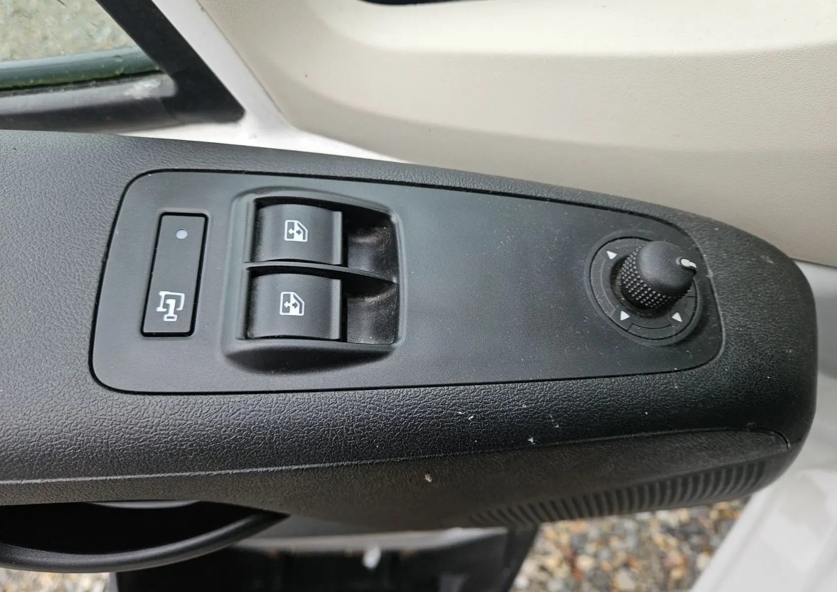 Gros plan sur les commandes de lève-vitres et réglage des rétroviseurs côté conducteur du Fiat Ducato Combi blanc 2014.
