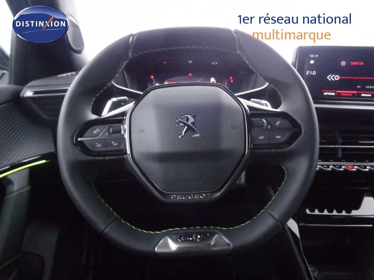 Volant cuir noir avec surpiqûres vertes du Peugeot 2008 GT 2023, tableau de bord numérique et écran tactile visible.