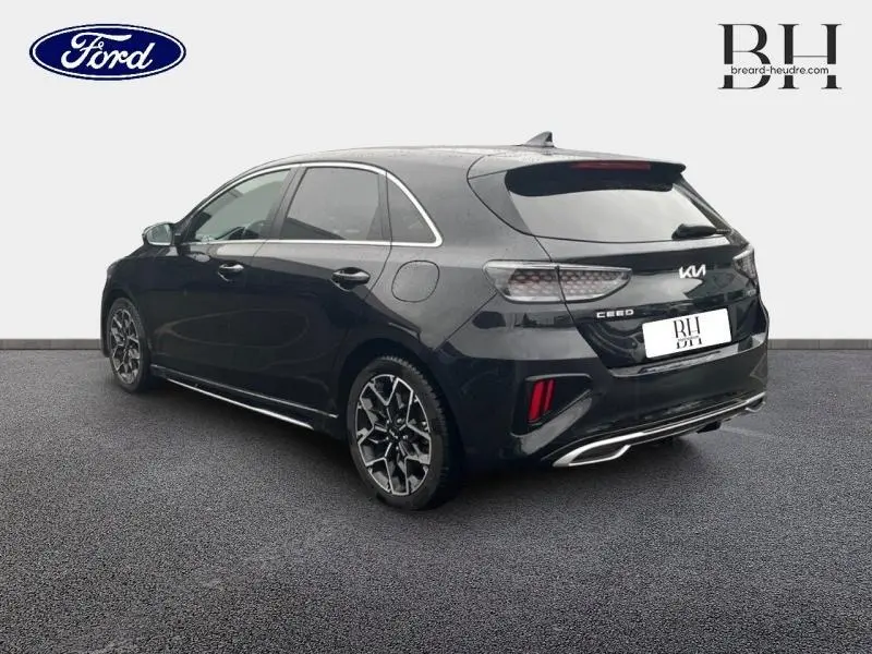 Vue 3/4 arrière droite d'une KIA CEE'D 1.0 T-GDI GT Line noire Basalte métallisé avec jantes alu distinctives.