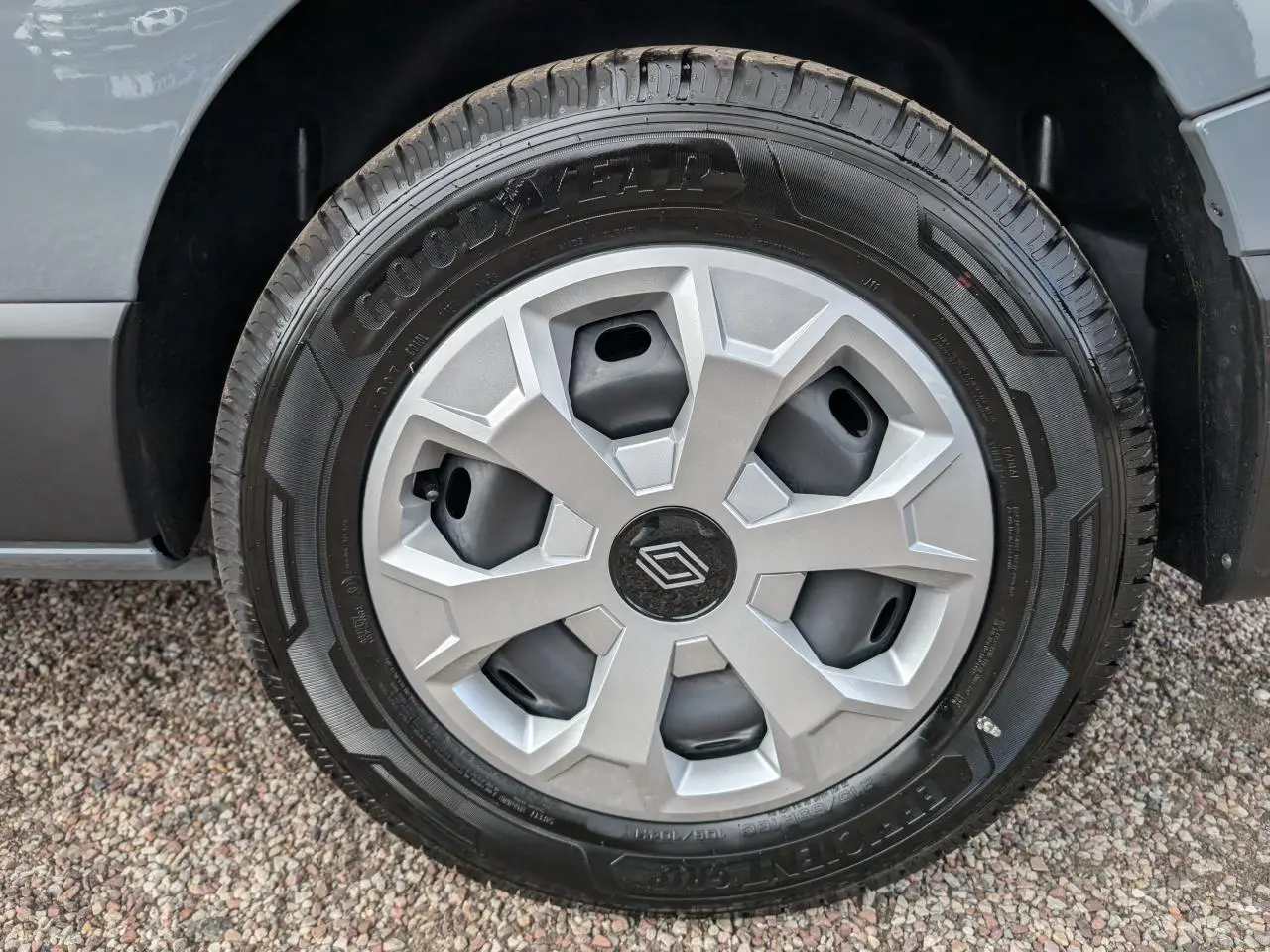 Gros plan sur la roue avant droite du Renault Trafic Fourgon gris, montrant le pneu et l'aile du véhicule.