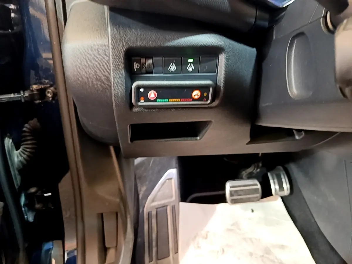Vue intérieure côté conducteur du Citroën C5 Aircross 2023, montrant les pédales et commandes de sécurité sur tableau noir.