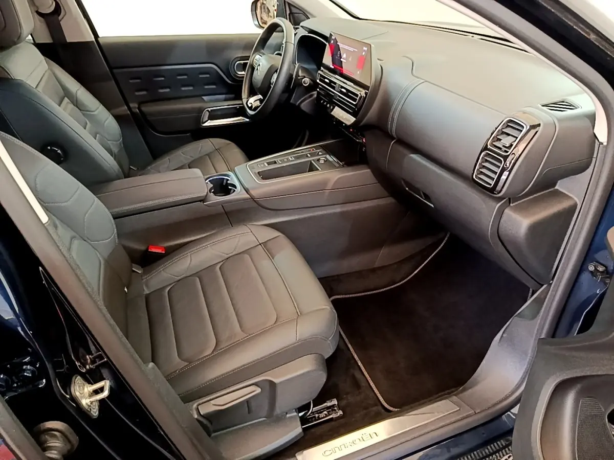 Vue intérieure côté passager avant du Citroën C5 Aircross 2023 avec sièges cuir noirs et tableau de bord digital.