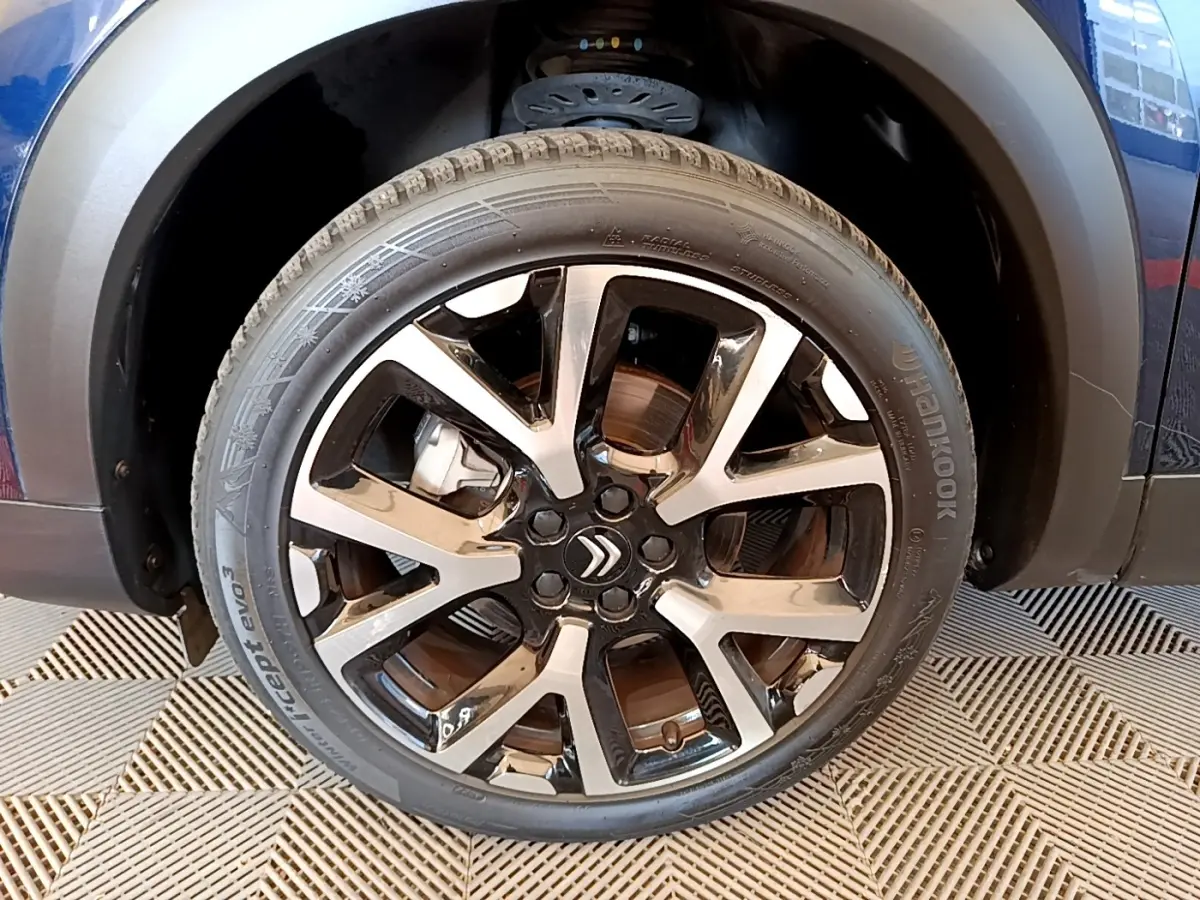 Gros plan sur la roue avant gauche du Citroën C5 Aircross 2023, jante alliage bicolore avec logo Citroën central.