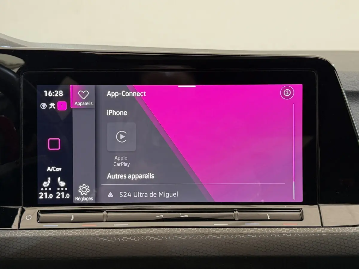Écran tactile central intérieur affichant Apple CarPlay dans une Volkswagen Golf gris foncé, vue de face.