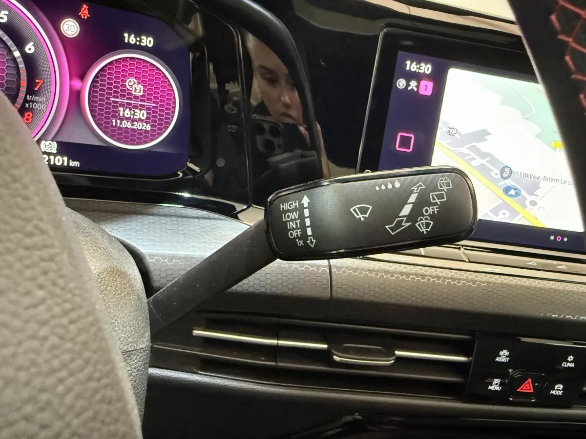 Vue intérieure du tableau de bord de la Volkswagen Golf GTI ClubSport 2022, avec affichage numérique violet et écran tactile de navigation.