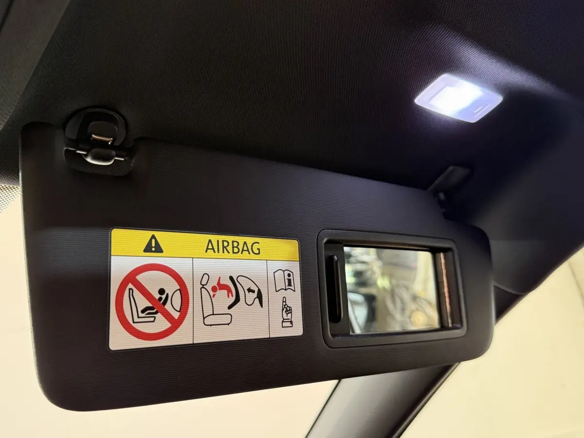 Détail du pare-soleil côté conducteur avec miroir et avertissement airbag dans une Volkswagen Golf gris foncé.