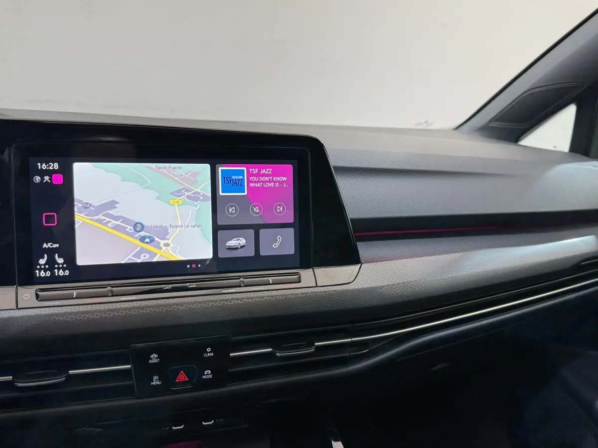 Tableau de bord de Volkswagen Golf GTI Clubsport 2022 avec écran tactile et ambiance lumineuse violette intégrée.