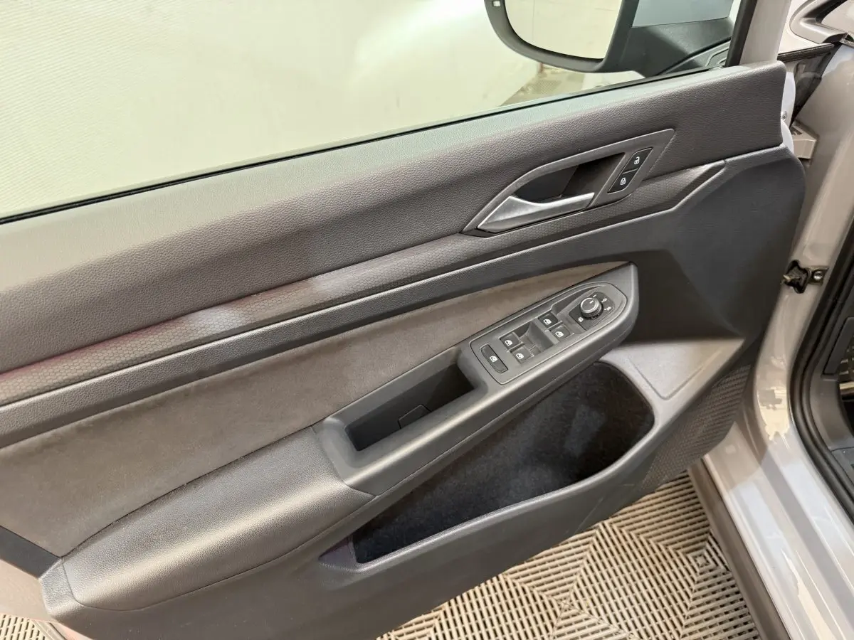 Vue rapprochée de la porte avant gauche grise d'une Volkswagen Golf 2.0 TSI 300 DSG7 GTI Clubsport avec commandes électriques.