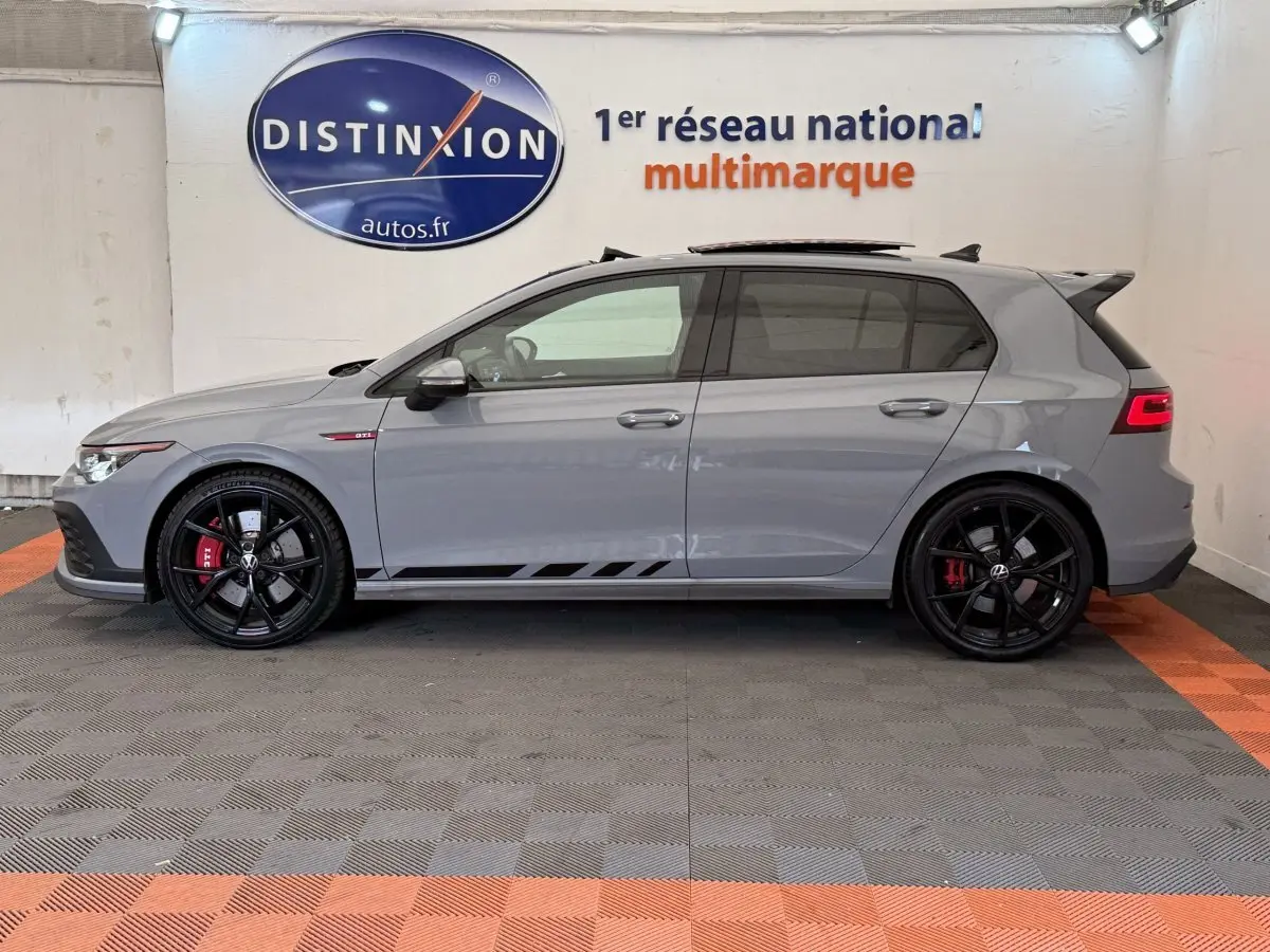 Vue de profil côté gauche d'une Volkswagen Golf GTI Clubsport 2022 gris foncé avec jantes noires et étriers rouges.