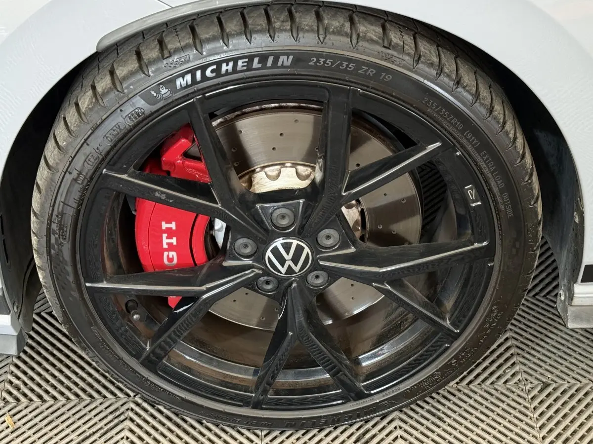 Gros plan sur la roue avant droite d'une Volkswagen Golf GTI Clubsport 2022, étrier rouge marqué GTI.