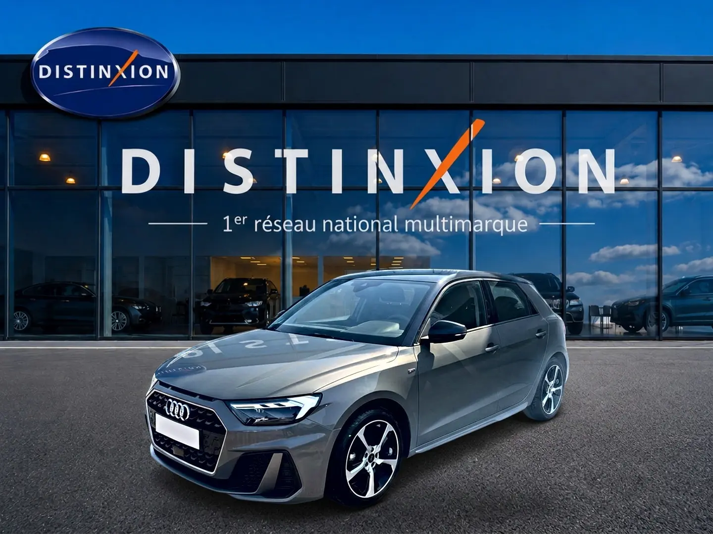 Audi A1 Sportback 30 TFSI gris chronos vue 3/4 avant droit avec jantes alu et toit noir devant showroom Distinxion.