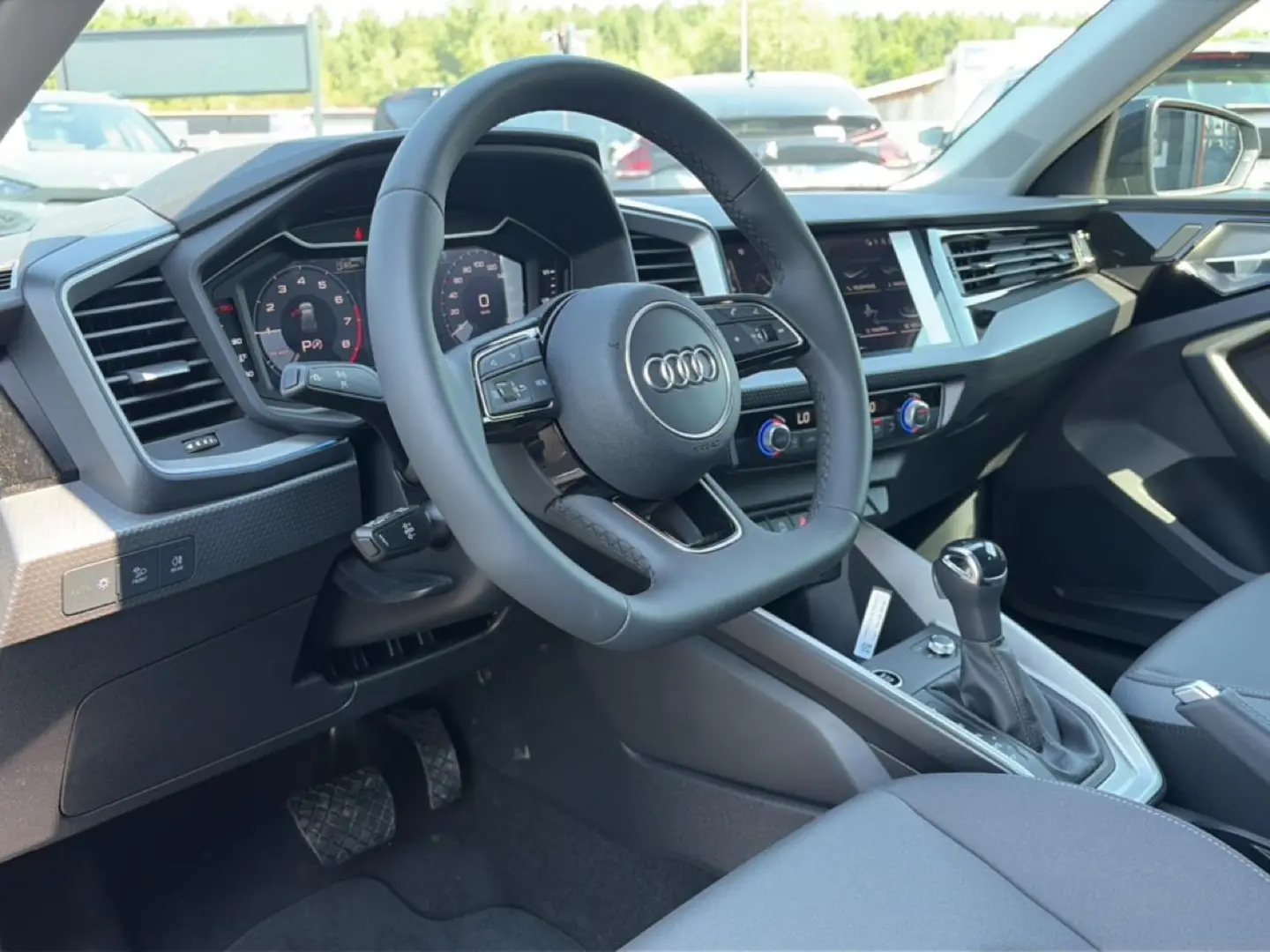 Vue intérieure côté conducteur de l'Audi A1 Sportback 2026 avec volant cuir multifonction et tableau de bord digital.