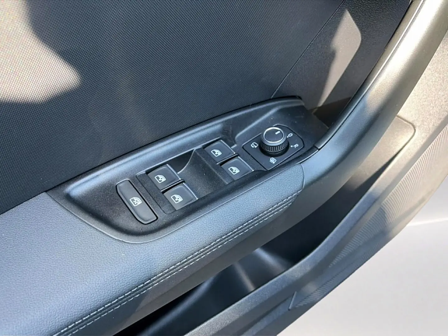Détail des commandes des vitres et rétroviseurs sur la porte avant gauche de l'Audi A1 Sportback gris chronos.