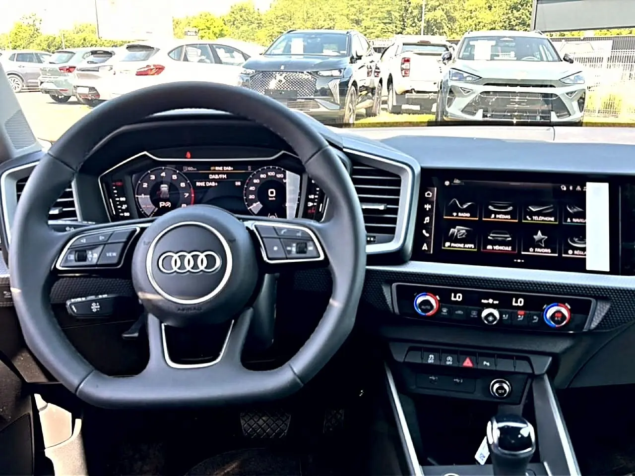 Vue intérieure du tableau de bord de l'Audi A1 Sportback 2026 avec volant multifonction et écran tactile central.