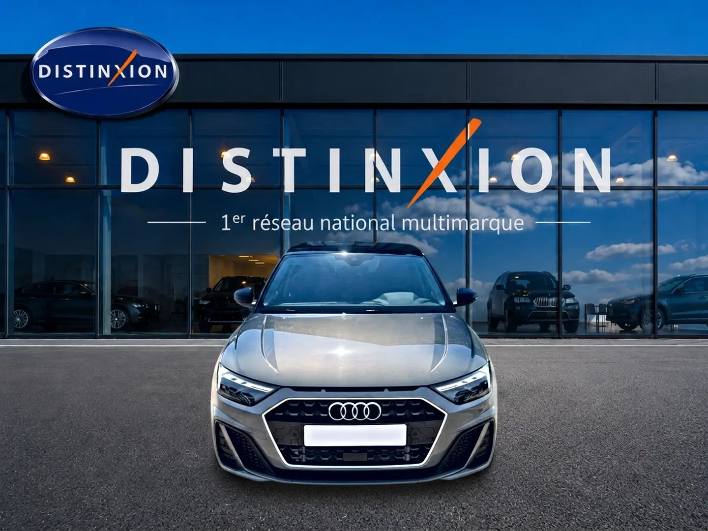 Audi A1 Sportback gris chronos vue de face, mettant en valeur la calandre hexagonale et les phares LED distinctifs.