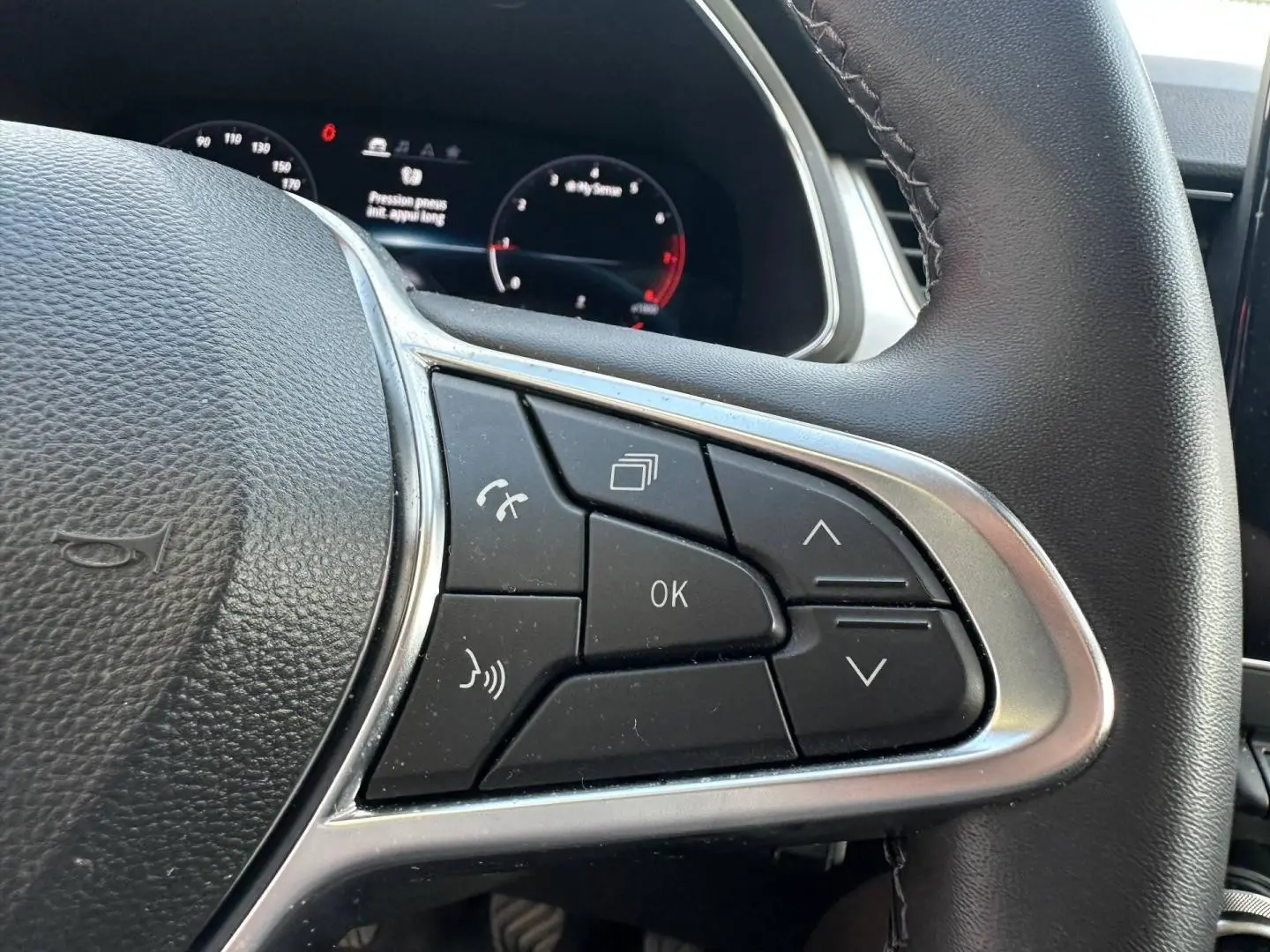 Gros plan sur les commandes multifonctions à droite du volant noir du Renault Captur 2024.