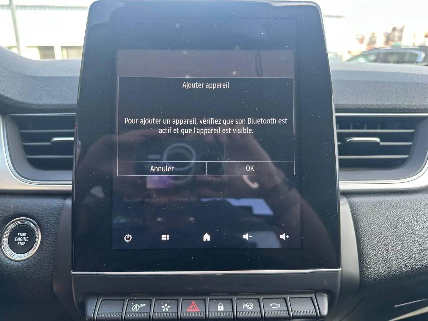 Vue rapprochée de l’écran tactile central du tableau de bord du Renault Captur 2024, avec message Bluetooth affiché.