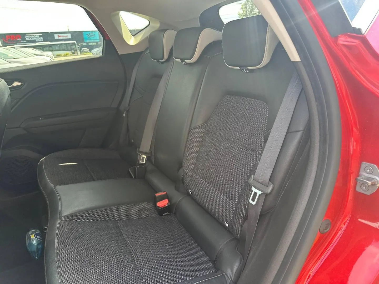 Vue intérieure côté droit des sièges arrière en tissu noir du Renault Captur Rouge Flamme nacré 2024.