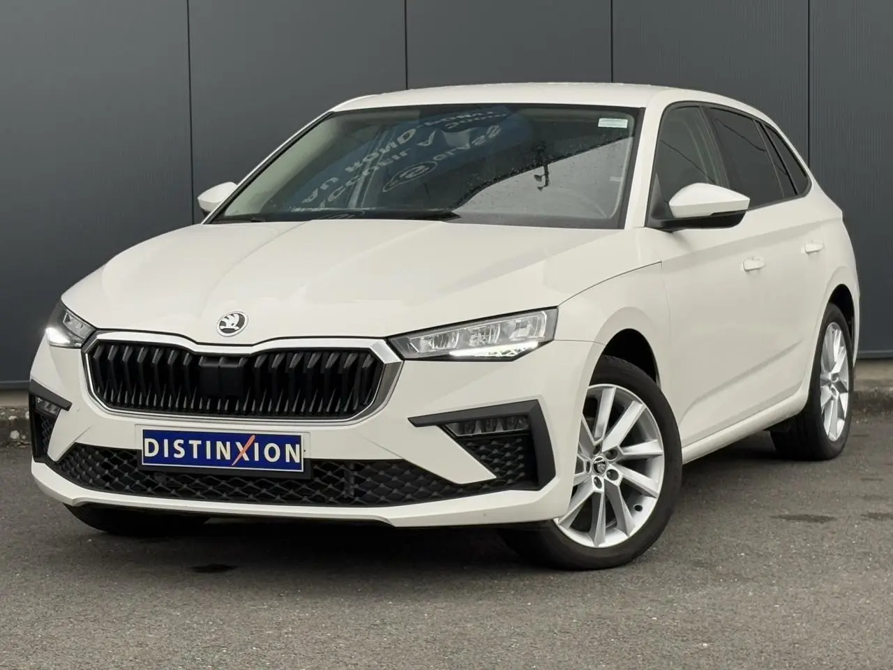 Vue 3/4 avant droite d'une Skoda Scala blanc Candy avec jantes alliage 17 pouces et calandre noire distinctive.