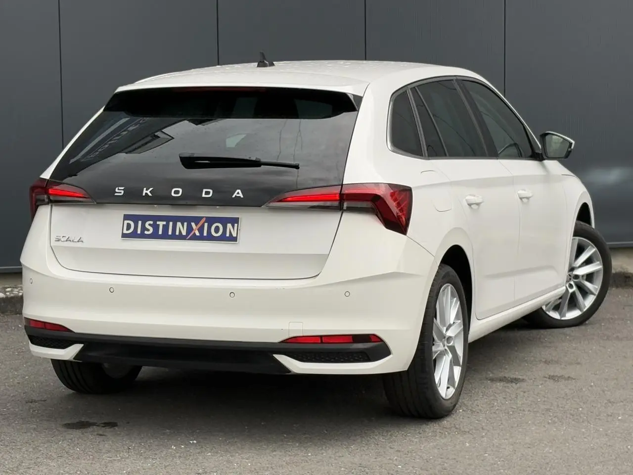 Vue 3/4 arrière droite d'une Skoda Scala blanc Candy avec jantes alliage 17 pouces et feux arrière LED distinctifs.