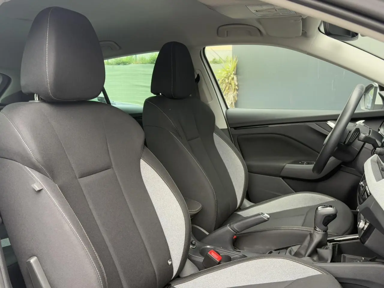Intérieur de la Skoda Scala 2024, vue côté droit sur sièges tissu bicolore gris et noir avec surpiqûres.