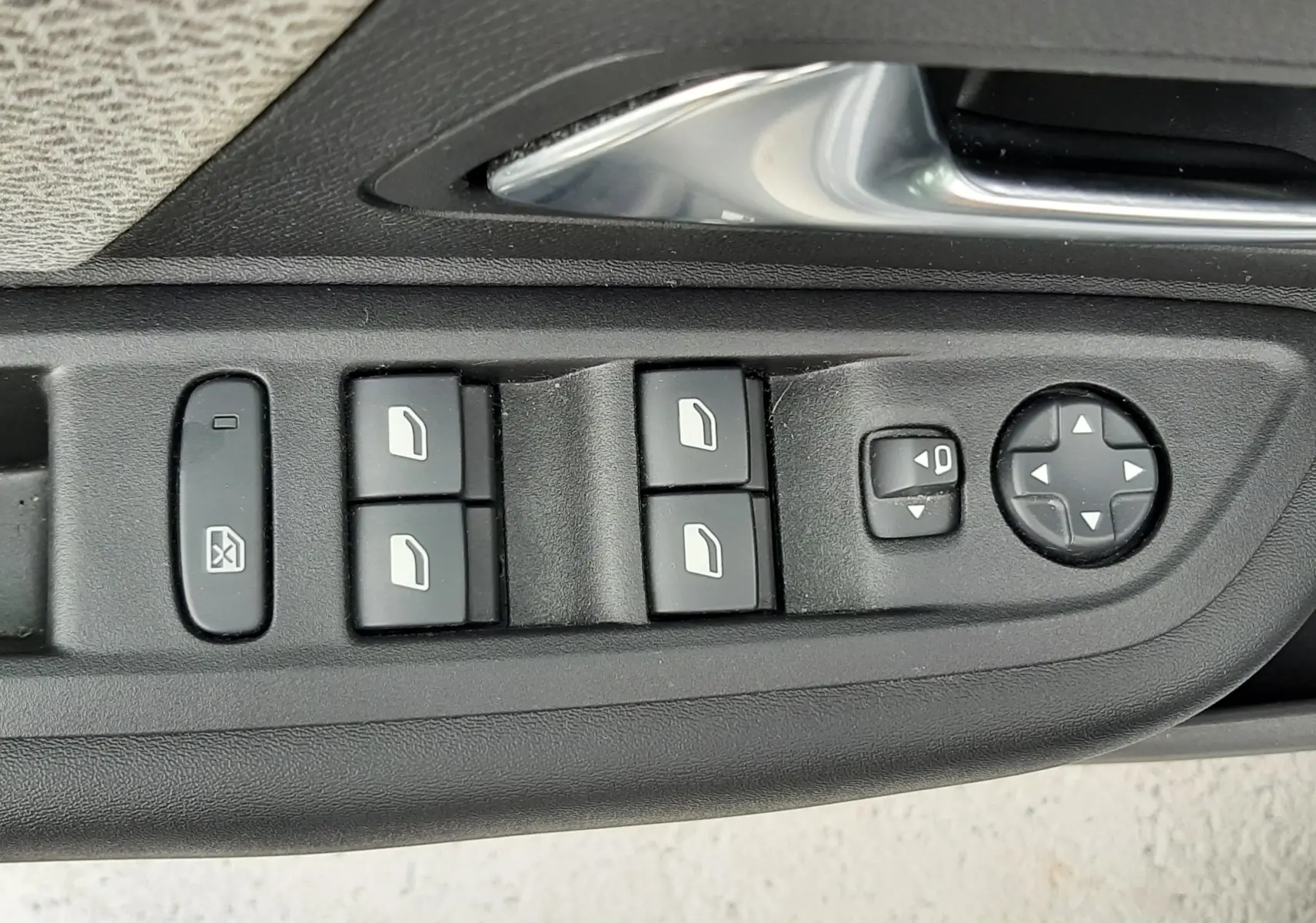 Gros plan sur les commandes de lève-vitres et réglages des rétroviseurs côté conducteur d'une Citroën C4 gris acier 2024.