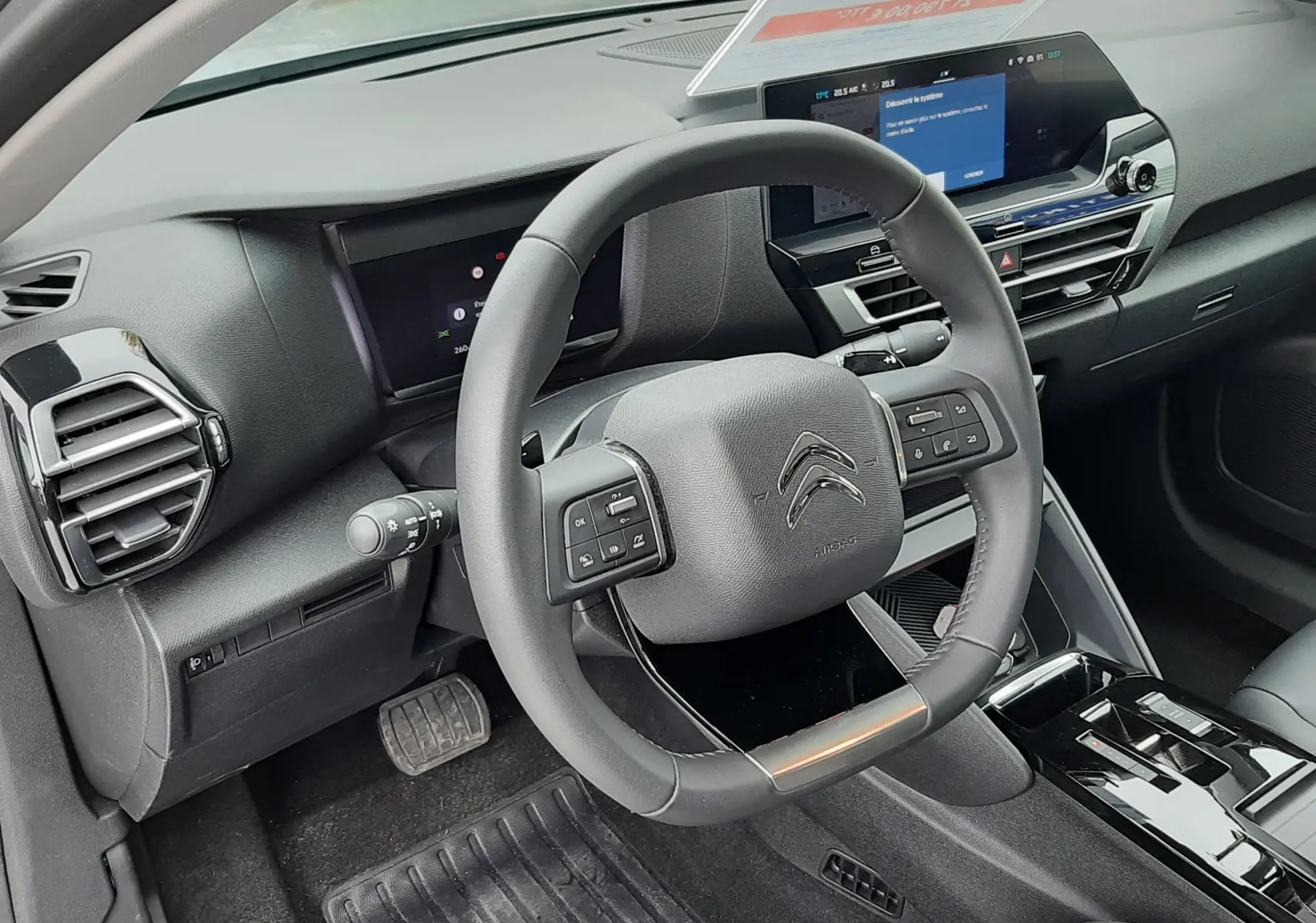 Vue intérieure du poste de conduite de la Citroën C4 Hybrid 136 e-DSC6 Plus 2024, avec volant multifonction et écran tactile.