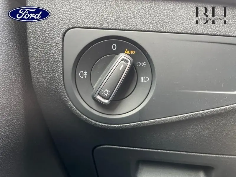 Gros plan sur la molette de réglage des phares du Volkswagen Tiguan noir intense nacrée, avec fonction auto visible.