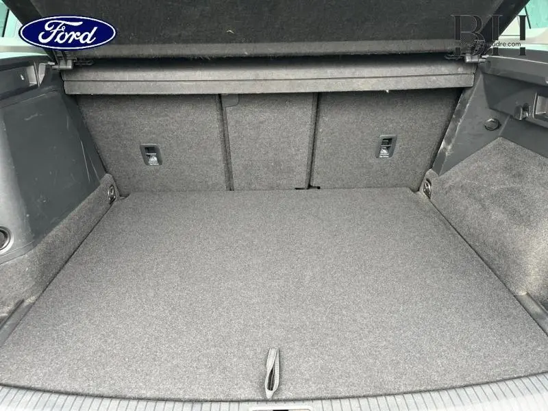 Coffre spacieux vu de face, revêtement gris, sans chargement, intérieur propre et bien fini.