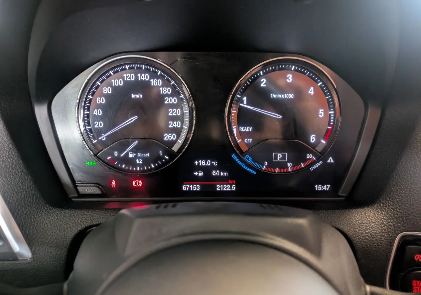 Vue rapprochée du tableau de bord numérique d'une BMW Série 2 Cabriolet noire, affichant vitesse, compte-tours et informations de conduite.