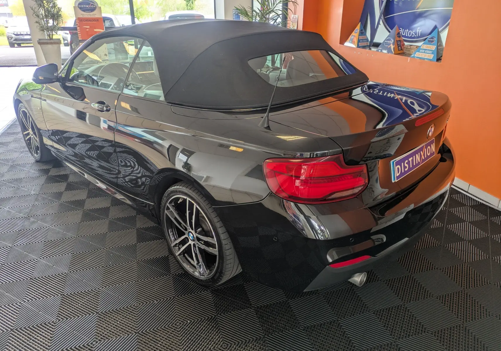 BMW Série 2 Cabriolet noir vue 3/4 arrière droit avec capote fermée et jantes alliage bicolores.