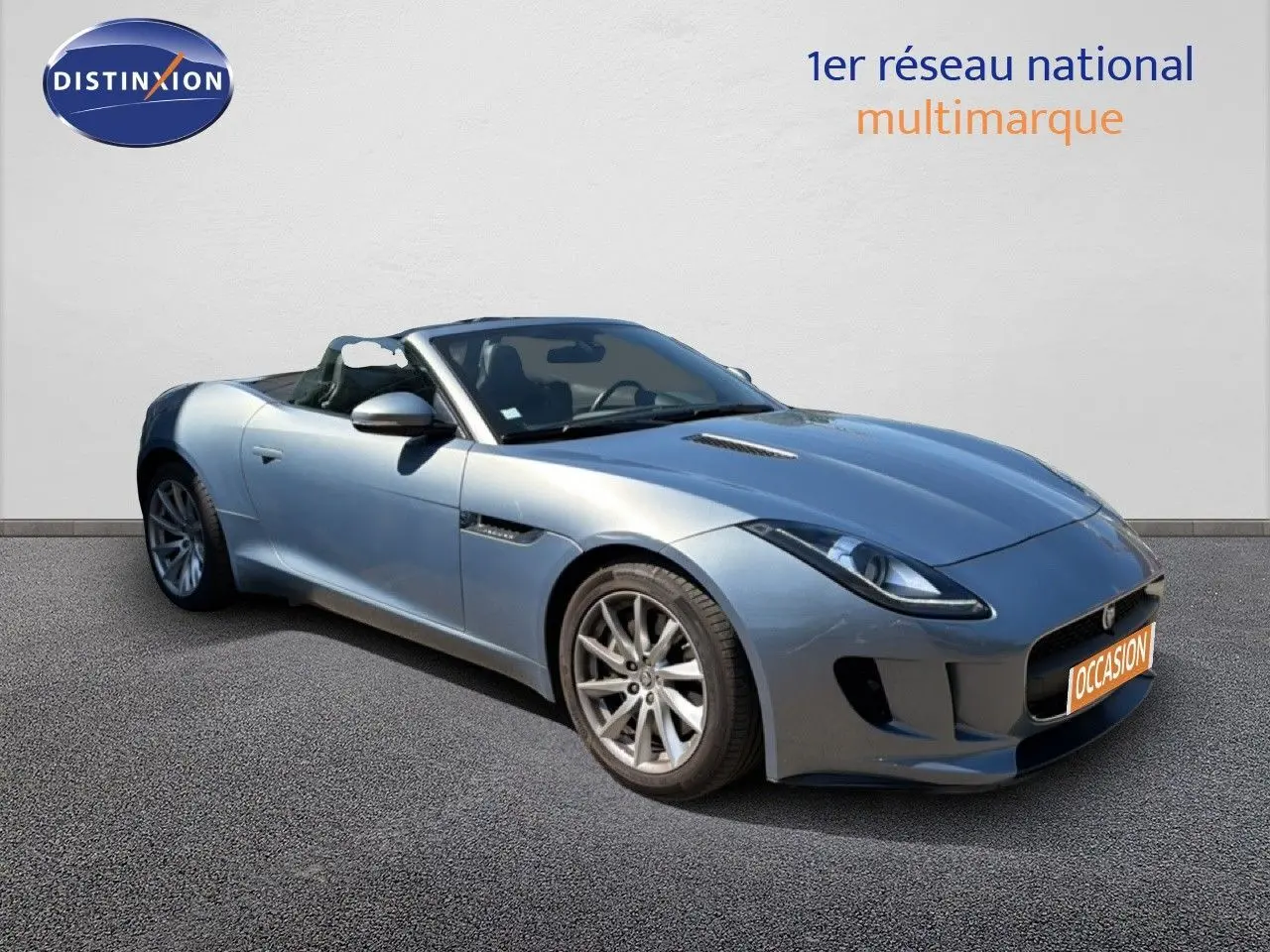 Jaguar F-TYPE cabriolet gris vue 3/4 avant droit, toit ouvert, jantes alliage et lignes sportives marquées.
