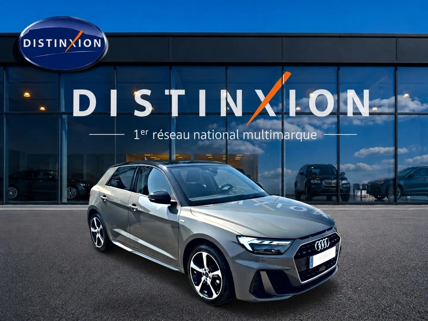 Audi A1 Sportback gris chronos vue 3/4 avant droit avec jantes alu et toit noir devant showroom Distinxion.