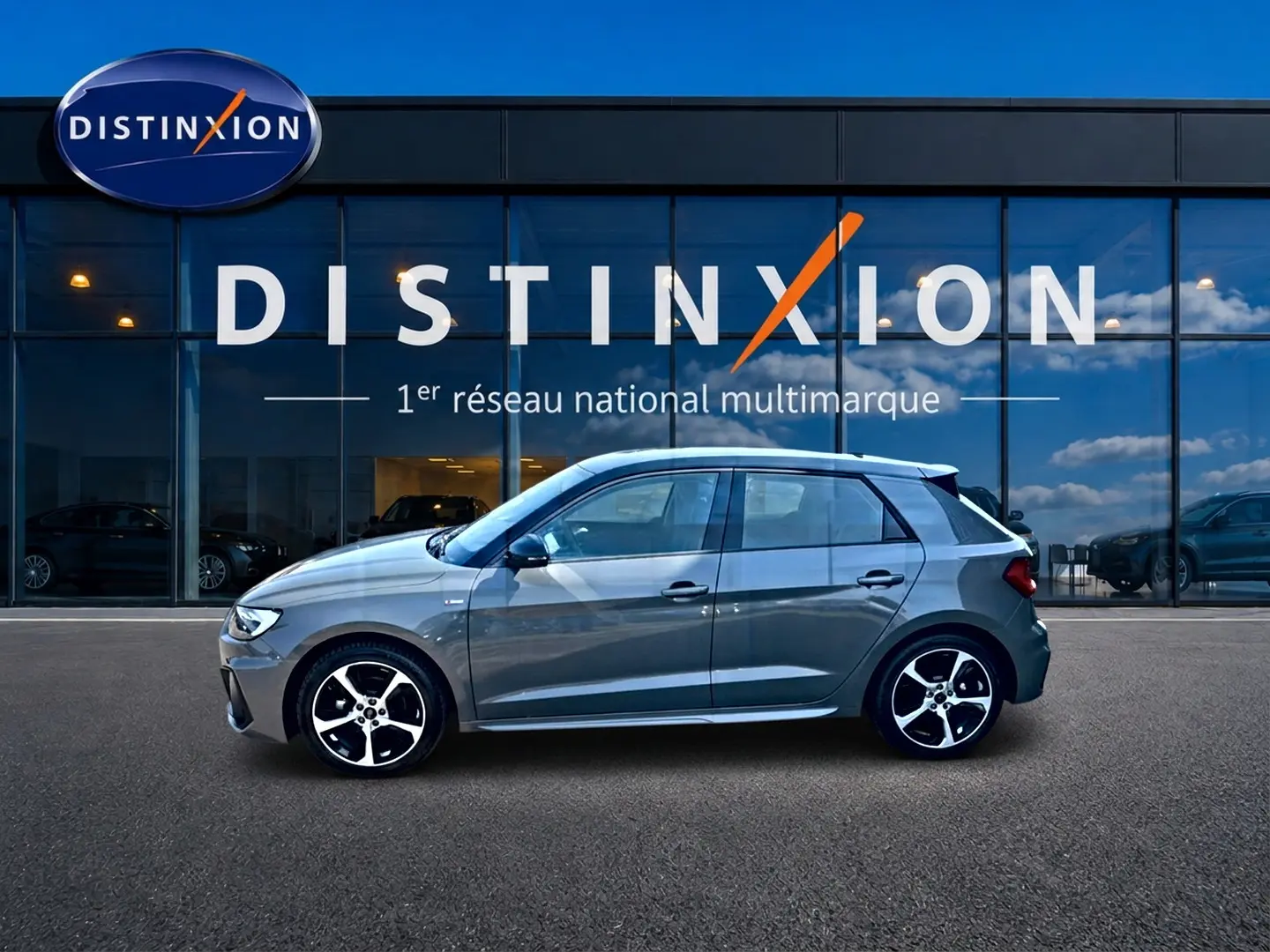 Audi A1 Sportback gris chronos vue de profil côté gauche avec jantes alu et toit noir devant showroom Distinxion.