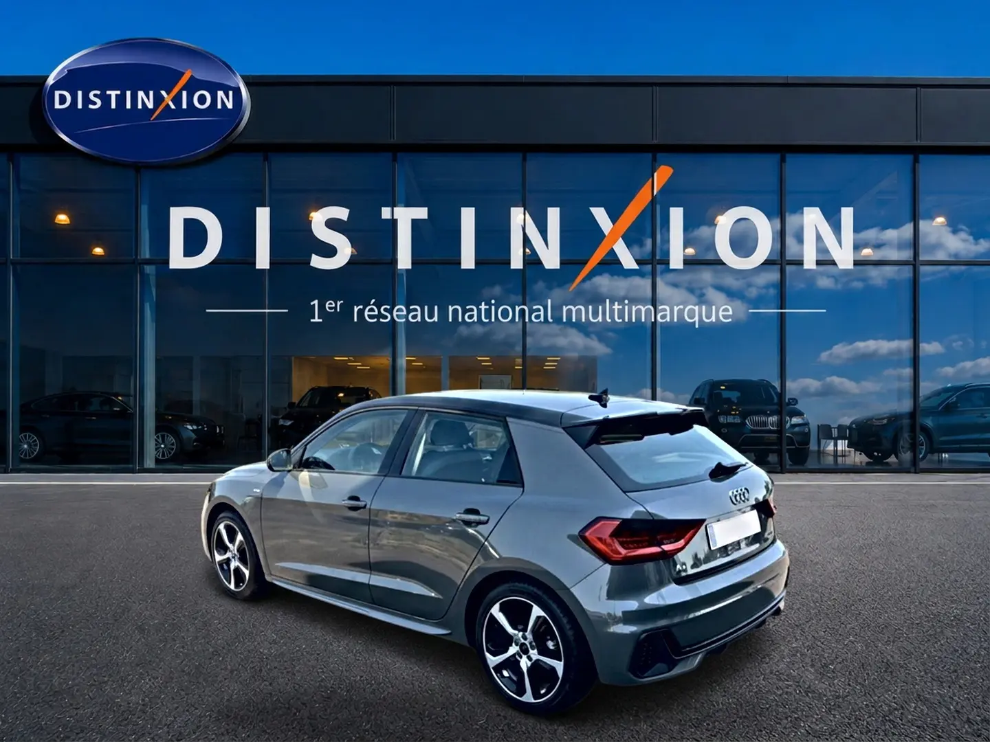 Audi A1 Sportback gris chronos vue 3/4 arrière droit, avec jantes alu et becquet noir distinctif.